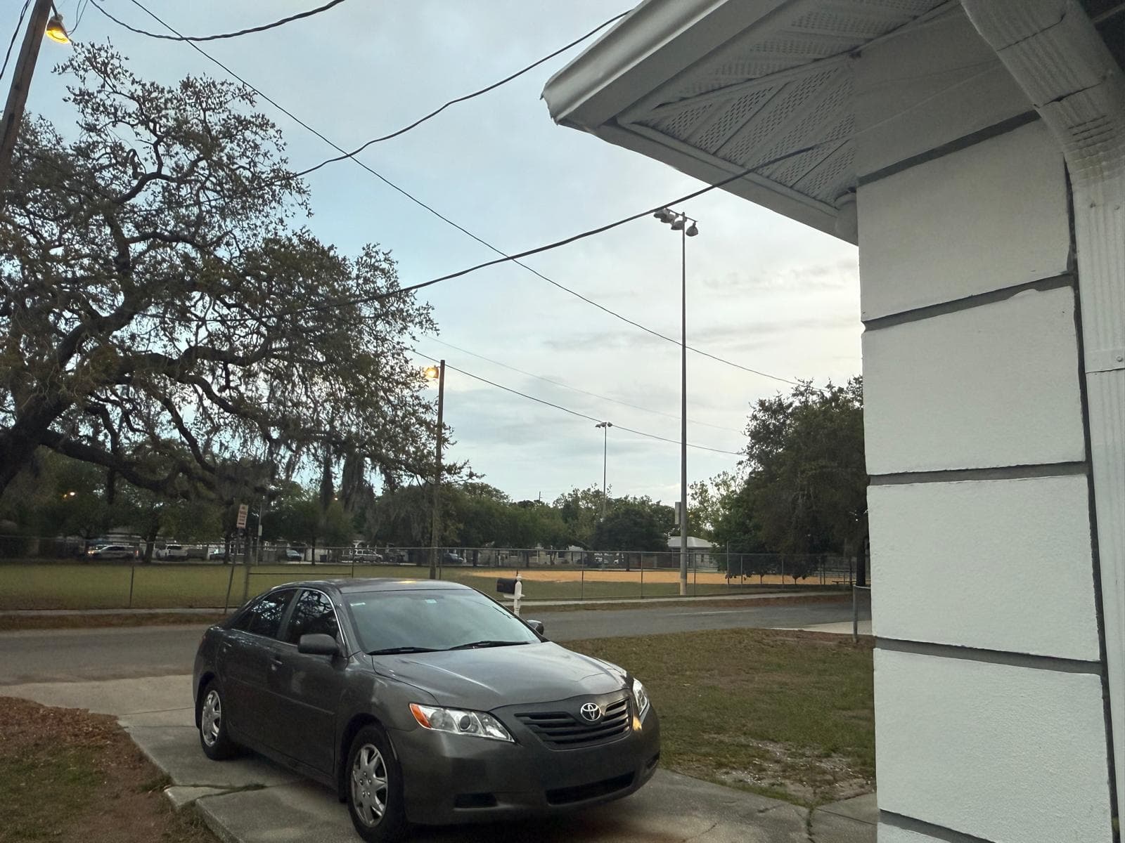 Covered porch view from ADOL FOSTER HOME looking toward a tree-lined Tampa street.