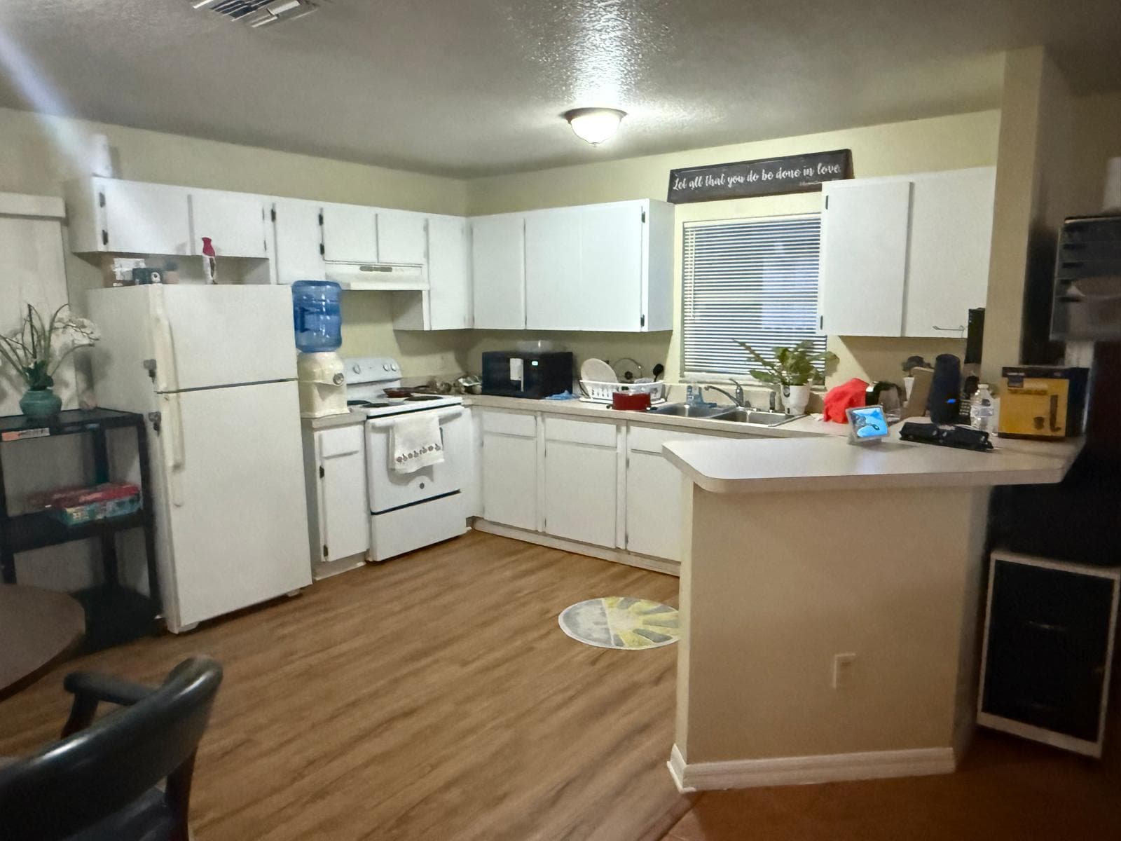 Kitchen with white cabinets, refrigerator, and stove at ADOL FOSTER HOME in Tampa.